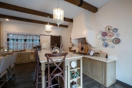 Spacious kitchen with a large island, wooden beams, and decorative plates