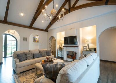 Spacious living room with vaulted ceiling and modern chandelier
