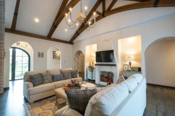 Spacious living room with vaulted ceiling and modern chandelier