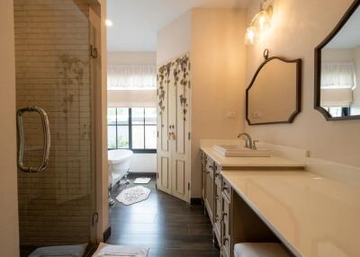 Spacious bathroom with double vanity, large mirror, and glass-enclosed shower