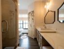 Spacious bathroom with double vanity, large mirror, and glass-enclosed shower