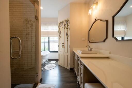 Spacious bathroom with double vanity, large mirror, and glass-enclosed shower