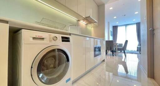 Modern kitchen with built-in appliances and a dining area in the background