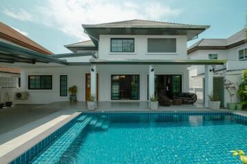 Exterior view of a modern two-story house with pool