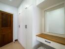 Bedroom with built-in white wardrobes and wooden door