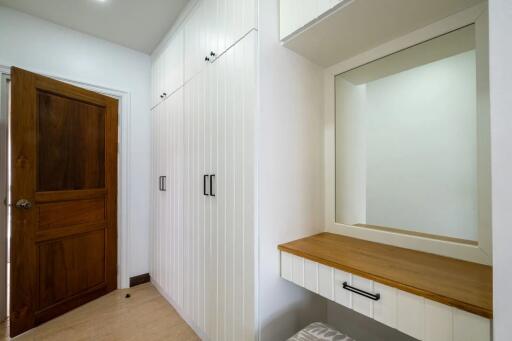 Bedroom with built-in white wardrobes and wooden door