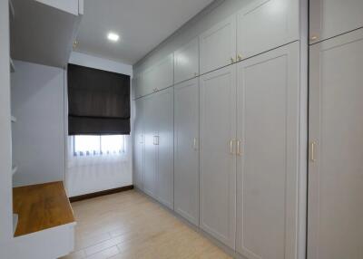 Bedroom with large white built-in wardrobes and wooden desk