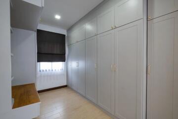 Bedroom with large white built-in wardrobes and wooden desk