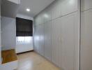 Bedroom with large white built-in wardrobes and wooden desk