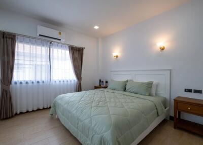 modern bedroom with double bed, nightstands, wall lamps, air conditioner, and large window with curtains
