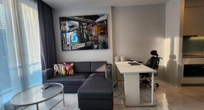 Modern living room with sofa, desk, and large window