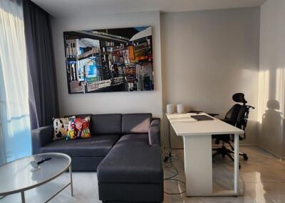 Modern living room with a sectional sofa and a home office setup.