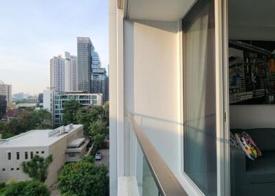 View from the balcony showing cityscape with buildings and greenery.