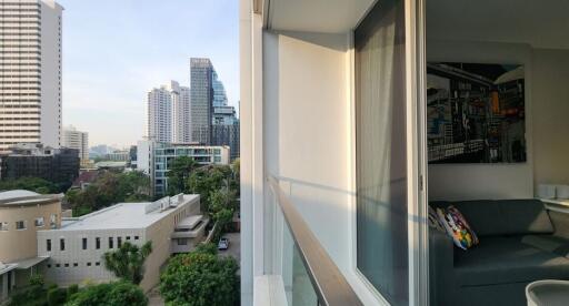 View from the balcony showing cityscape with buildings and greenery.