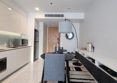 Modern kitchen and dining area with sleek white cabinetry and stylish decor.