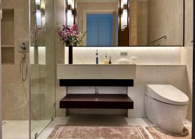 Modern bathroom with glass shower, vanity sink, and toilet