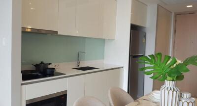 Modern kitchen with sleek white cabinets, built-in appliances, and a small dining area