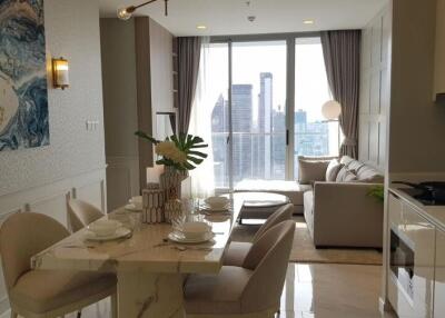 Modern living and dining area with city view, elegant furniture, and natural light