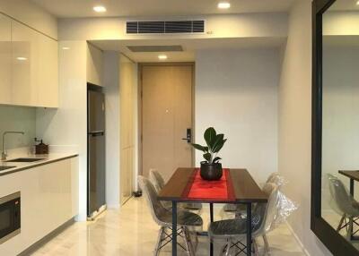 Modern kitchen and dining area with a table, chairs, and indoor plant