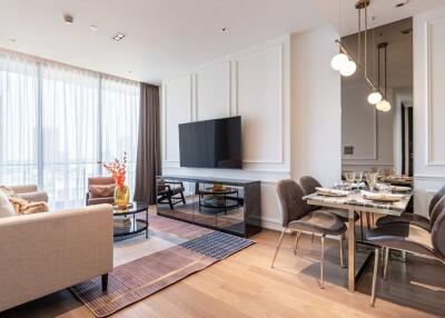 Modern living room with large TV, dining area, and natural light