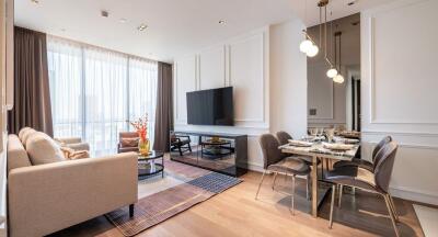 Modern living room with large TV, dining area, and natural light