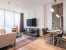 Modern living room with large TV, dining area, and natural light