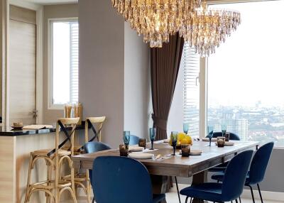 Modern dining room with chandelier, dining table, and chairs.