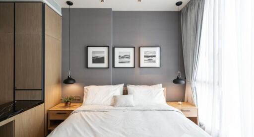 Modern bedroom with a king-sized bed, wooden side tables, and large windows.