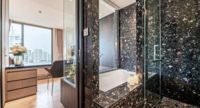 Modern bathroom with dark marble and an adjacent living area with large window