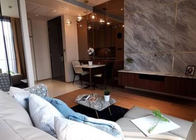 Modern living space with a comfortable sofa, coffee table, dining area, and a marble feature wall