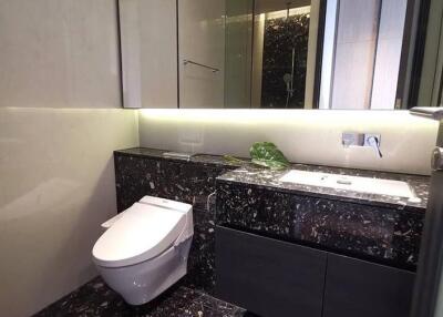 Modern bathroom with sleek black marble counter and toilet