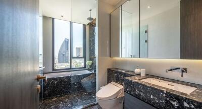 Modern bathroom with city view, featuring a bathtub, toilet, and sink with a marble countertop