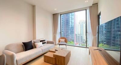 Modern living room with large window overlooking city buildings