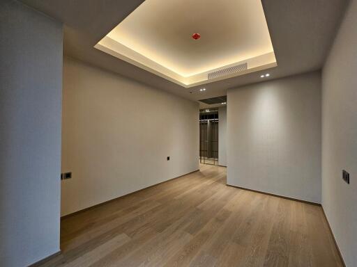 Empty room with wooden flooring and recessed ceiling lighting