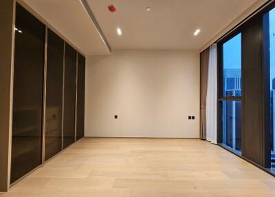 Empty modern bedroom with large windows and built-in closets