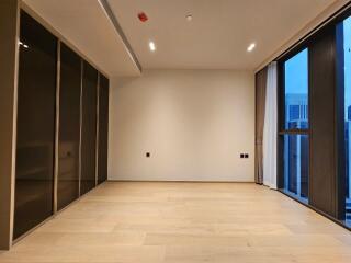 Empty modern bedroom with large windows and built-in closets