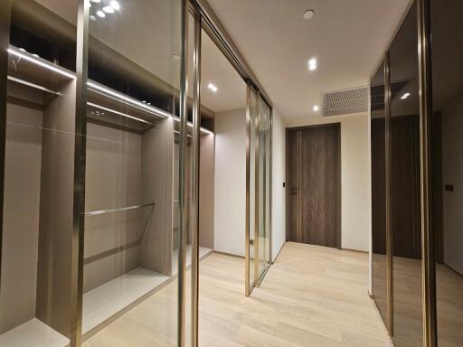 Spacious walk-in closet with floor-to-ceiling mirrors and multiple storage compartments