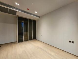 Modern minimalist bedroom with wooden flooring and large wardrobe