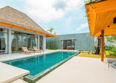 Modern outdoor pool area with lounge chairs and adjacent building