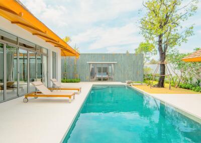 Modern outdoor pool area with lounge chairs and glass sliding doors