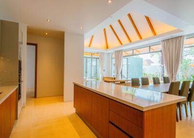 Modern kitchen and dining area with wooden finishes and large windows