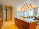 Modern kitchen and dining area with wooden finishes and large windows