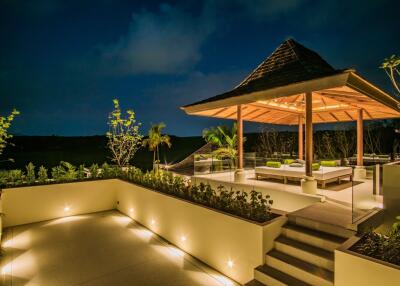 Elegant outdoor pavilion at night with seating area