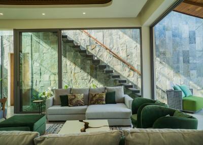 Modern living room with large windows and a view of a stone staircase
