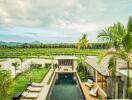 View of a swimming pool in the backyard of a house with lounge chairs, a garden, and scenic landscape