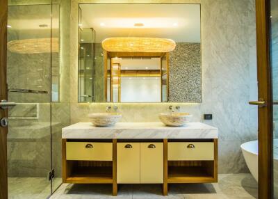 Modern bathroom with dual sinks on marble countertop and large mirrors