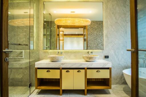 Modern bathroom with dual sinks on marble countertop and large mirrors