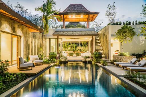 Luxury villa with pool and lush vegetation at twilight