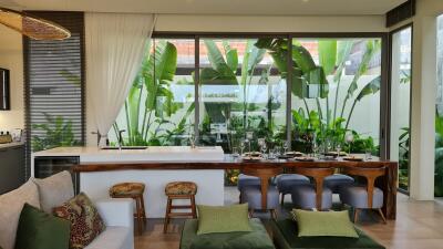 Modern living and dining area with large windows and garden view