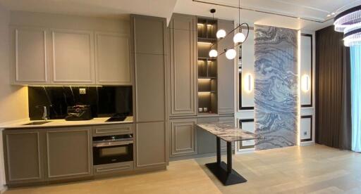 Modern kitchen with sleek cabinetry, built-in oven, and hanging lights.